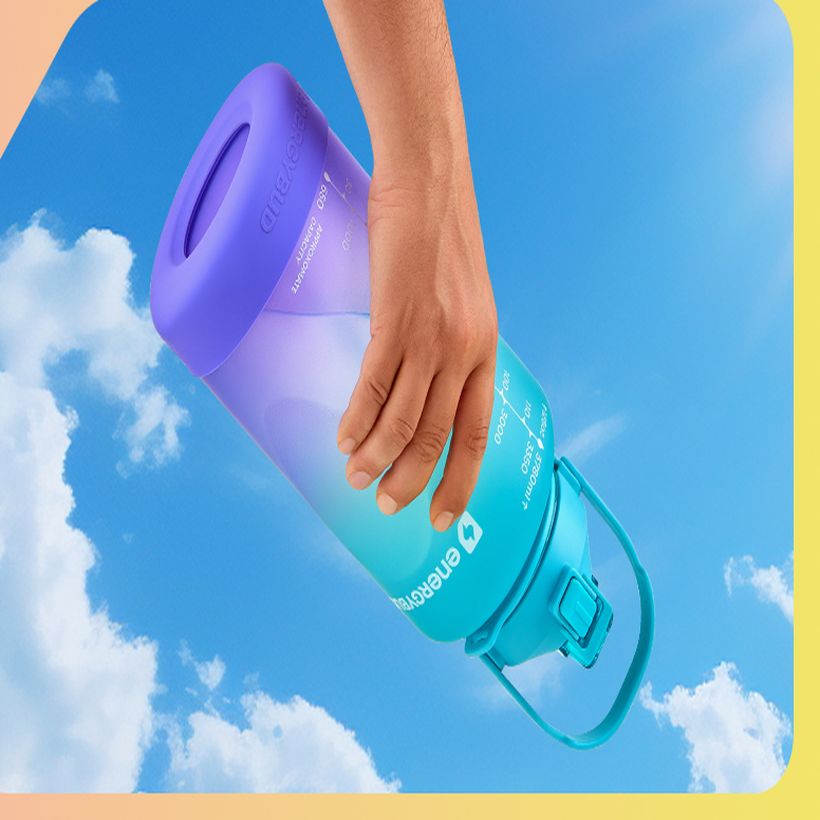 A hand tilting a sealed EnergyBud bottle sideways in mid-air